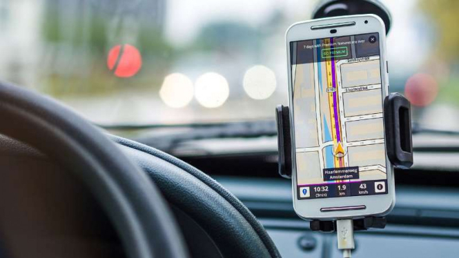 Ilustrasi mengemudi sembari mengoperasikan perangkat GPS lewat gawai.