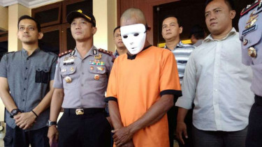 Polisi memperlihatkan tersangka pencabulan terhadap anak kandungnya di Kabupaten Garut, Jawa Barat, pada Kamis, 5 April 2018.