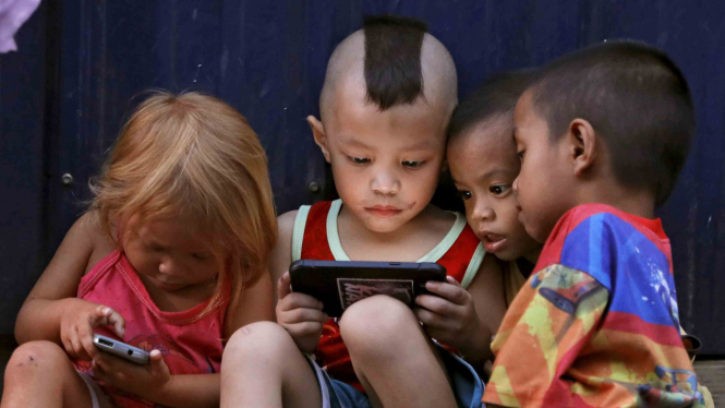 Anak-anak melihat gadget.
