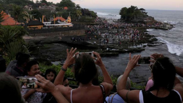 Turis lokal dan asing berfoto di Tanah Lot Tabanan Bali.