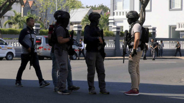 Polisi berjaga-jaga dekat lokasi ledakan bom di Mapolrestabes Surabaya, 14 Mei 2018.