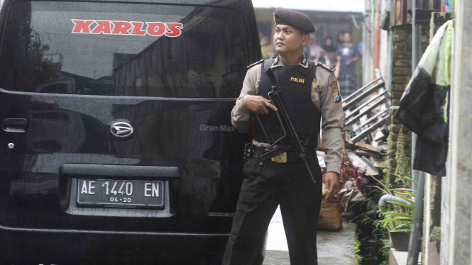 Polisi bersenjata senapan laras panjang melakukan penjagaan.