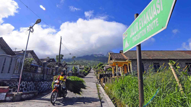 Warga mengendarai motor di jalan pedesaan lereng Gunung Merapi