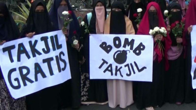 Sejumlah wanita bercadar bagi-bagi takjil.