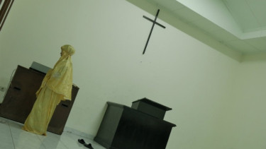 Foto wanita salat di Gereja Ayam, Pasar Baru, Jakarta.