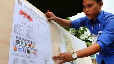 Ilustrasi Petugas KPPS merapikan poster Pilkada Serentak di Deli Serdang