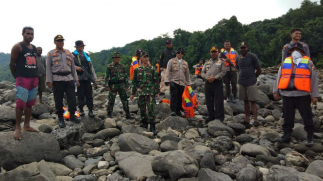 Aparat Kepolisian dibantu warga mencari anggota yang hilang.