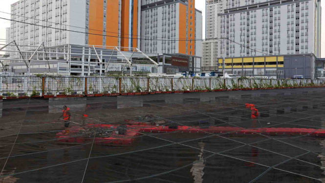 Penutupan waring untuk mengurangi bau di Kali Item, dekat Wisma Atlet Kemayoran