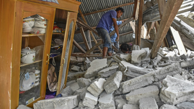 Warga mencari perlengkapan wisatawan asal Malaysia yang tewas tertimpa rumah roboh akibat gempa, di Desa Sajang, Kecamatan Sembalun, Selong, Lombok Timur, NTB, Minggu (29/7/2018).