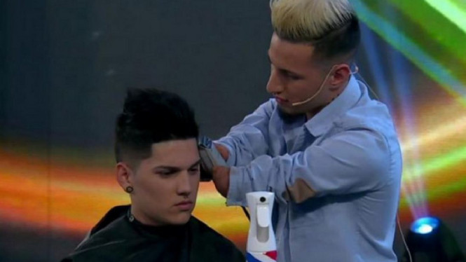 Gabriel Heredia sedang memangkas rambut pelanggannya