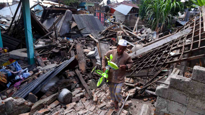 Warga mengangkat sepeda dari reruntuhan rumah yang rusak akibat gempa bumi di Lombok Barat, NTB, 2018 lalu.
