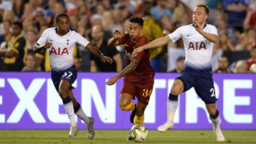 Striker AS Roma, Justin Kluivert (tengah) diapit pemain Tottenham Hotspur.