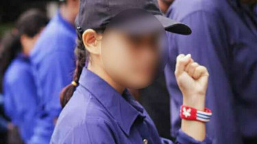 Seorang wanita mengenakan gelang bergambar Bintang Kejora.