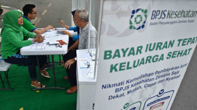 Petugas BPJS Kesehatan memberikan informasi kepada warga