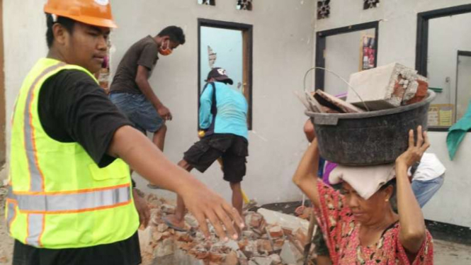 Pengungsi di Lombok Barat bersama relawan membangun kembali rumah mereka.