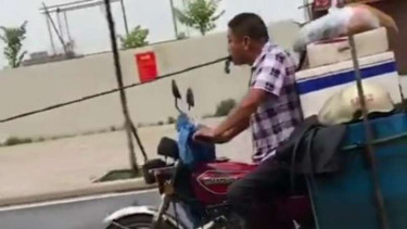 Pengendara motor menggigit tali derek