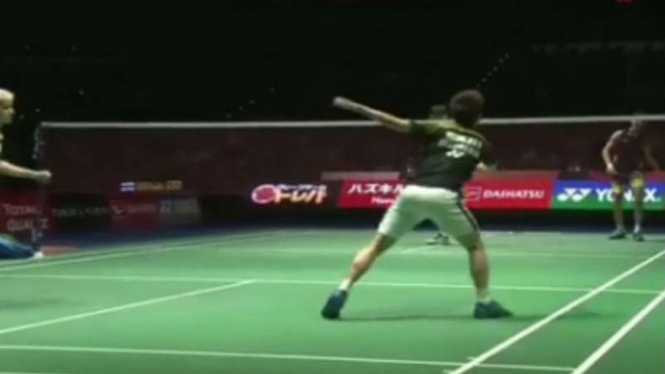 Kevin Sanjaya saat mengayun raket ketika shuttlecock tersangkut di net.