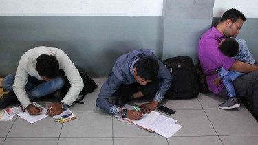 Pencari kerja menyiapkan dokumen persyaratan lamaran kerja saat bursa kerja