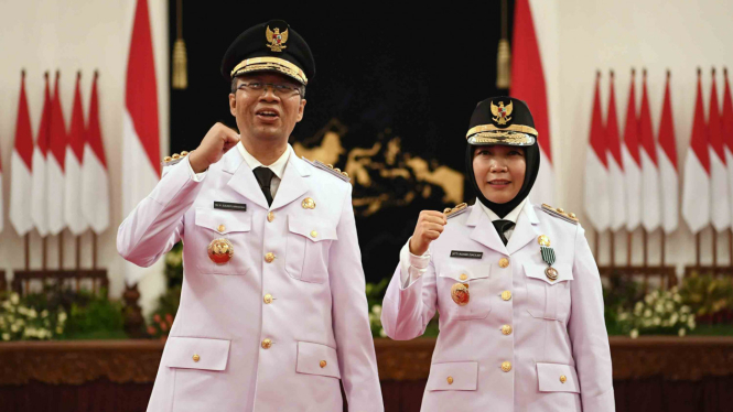 Gubernur Nusa Tenggara Barat (NTB) Zulkifliemansyah (kiri) bersama Wakil Gubernur Sitti Rohmi Djalilah mengangkat tangan seusai pelantikan di Istana Negara Jakarta