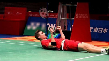 Victor Axelsen tersungkur di lapangan.