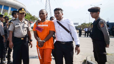 Petugas Polrestabes Bandung membawa seorang tersangka saat menggelar rekonstruksi pengeroyokan yang dilakukan oleh oknum bobotoh terhadap seorang suporter Persija, Haringga Sirla, di Stadion Gelora Bandung Lautan Api (GBLA), Bandung, Jawa Barat.