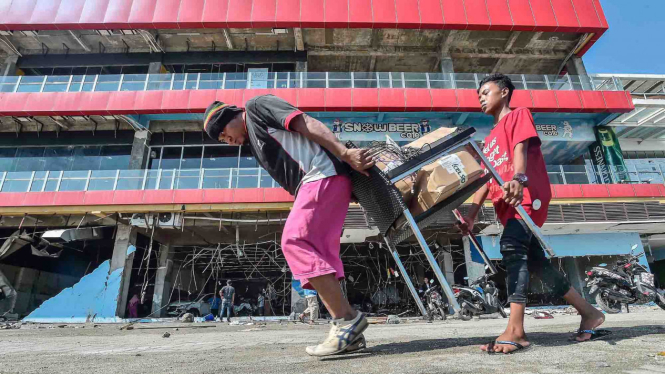 Warga mengambil barang yang ada di mall PGM pascatsunami di wilayah Talise, Palu