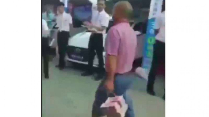Pria tenteng uang tunai untuk membeli mobil