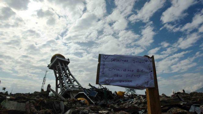 Warga memasang tulisan doa untuk keluarganya di lokasi terdampak pergerakan atau pencairan tanah (likuifaksi) di Balaroa Palu, Sulawesi Tengah