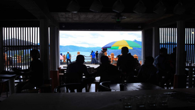 Pengunjung menyeruput kopi di atas puncak bukit Pantan Terong, Takengon, Aceh