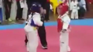 Dua bocah tanding taekwondo.