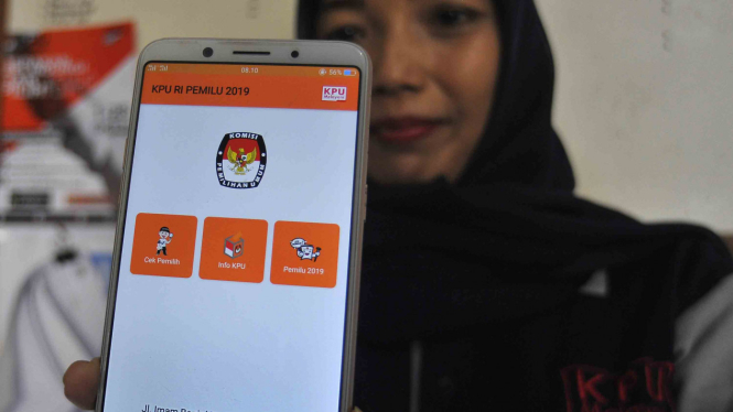 Seorang warga memperlihatkan aplikasi KPU RI pada layar ponsel.