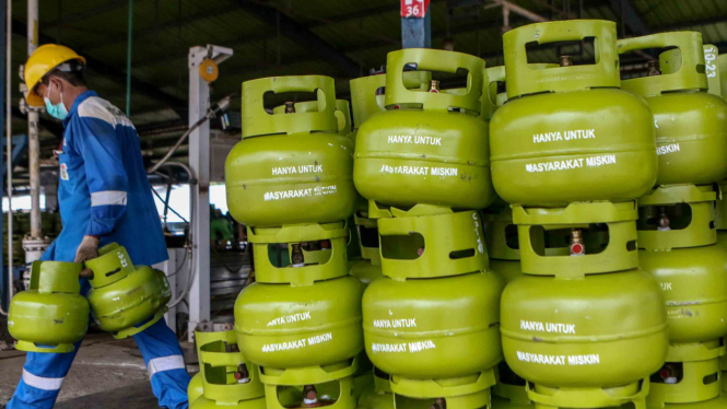 Pekerja menyusun tabung Liquefied Petroleum Gas (LPG)  ukuran tiga kilogram
