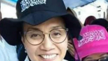 Sri Mulyani memakai topi berkalimat tauhid.