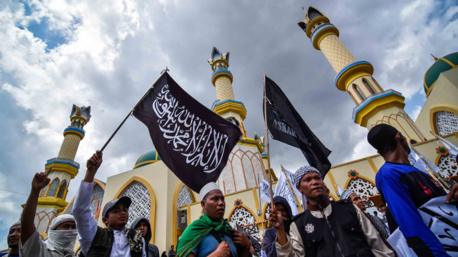 Sejumlah pengunjuk rasa membawa bendera bertuliskan kalimat tauhid saat mengikuti aksi bela tauhid di Mataram, NTB