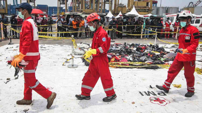 Petugas membawa puing-puing pesawat saat serah terima barang temuan kecelakaan Lion Air JT 620 di Pelabuhan Tanjung Priok, Jakarta