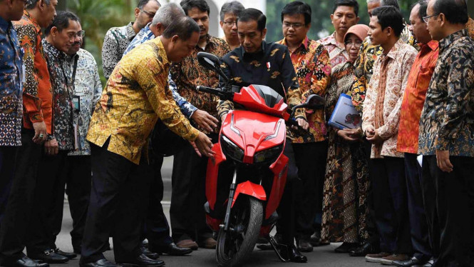 Presiden Joko Widodo (tengah) mendengarkan penjelasan dari Menristekdikti M Nasir (kelima kiri) sebelum menjajal motor listrik buatan dalam negeri 'Gesits' seusai melakukan audiensi dengan pihak-pihak yang terlibat proses produksi di halaman tengah Istana