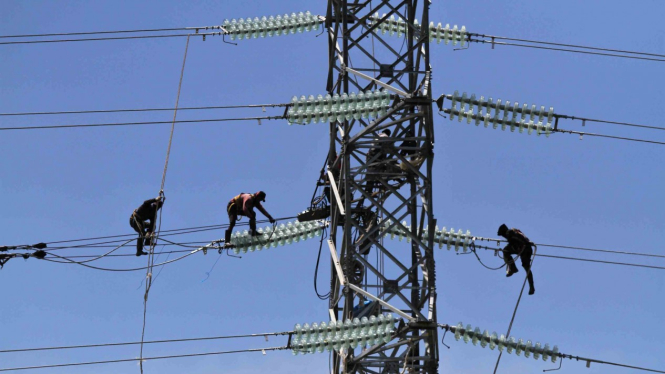 Pekerja memasang jaringan kabel ke tower milik PT PLN Persero yang akan dialiri listrik dari PLTU IPP 3 Kendari, di Desa Pousu Jaya, Konda, Konawe Selatan, Sulawesi Tenggara