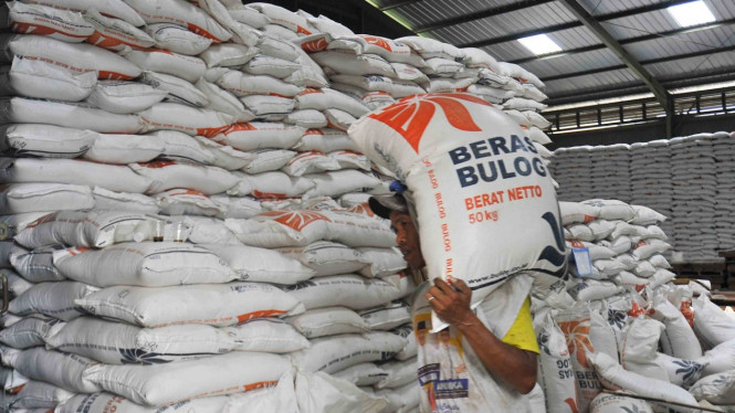 Pekerja mengangkut karung berisi beras stok Rasta/Raskin (beras untuk warga prasejahtera) di Gudang Bulog Serang, Banten