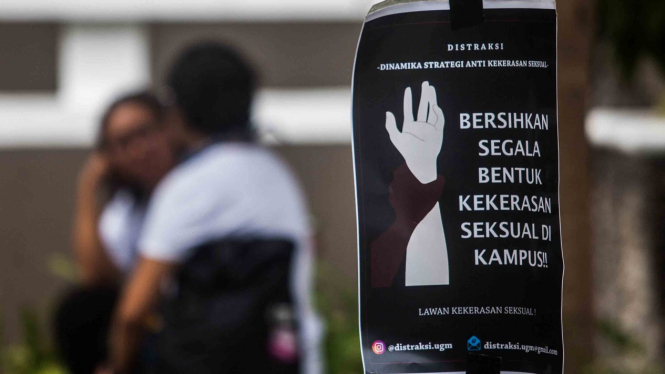Mahasiswa berada di dekat poster penolakan terhadap kekerasan seksual saat aksi damai Universitas Gadjah Mada (UGM) Darurat  Kekerasan Seksual di Kampus Fisipol UGM, Sleman, DI Yogyakarta