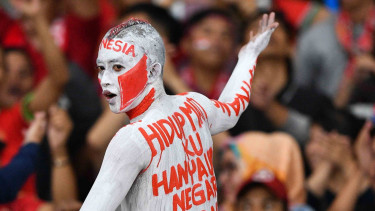 Suporter memberikan dukungan kepada timnas Indonesia di Stadion Utama Gelora Bung Karno, Jakarta