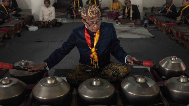 Sejumlah pengrawit dari abdi dalem dan kerabat Keraton Kasunanan Surakarta Hadiningrat Solo menabuh gamelan Kyai Guntur Sari di Bangsal Pradonggo di halaman Masjid Agung Keraton, Solo, Jawa Tengah