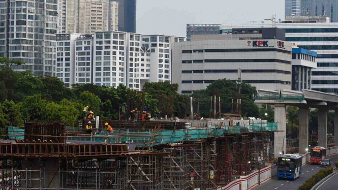 Pekerja mengerjakan proyek pembangunan jalur kereta api ringan atau light rail transit (LRT) Jabodebek koridor Cawang–Kuningan–Dukuh Atas di Jalan Rasuna Said, Kuningan, Jakarta