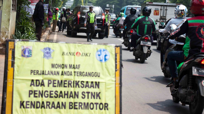 Petugas gabungan memeriksa pajak kendaraan bermotor saat razia pengesahan Surat Tanda Nomor Kendaraan (STNK) di kawasan Taman Makam Pahlawan Kalibata, Jakarta, Senin, 19 November 2018.