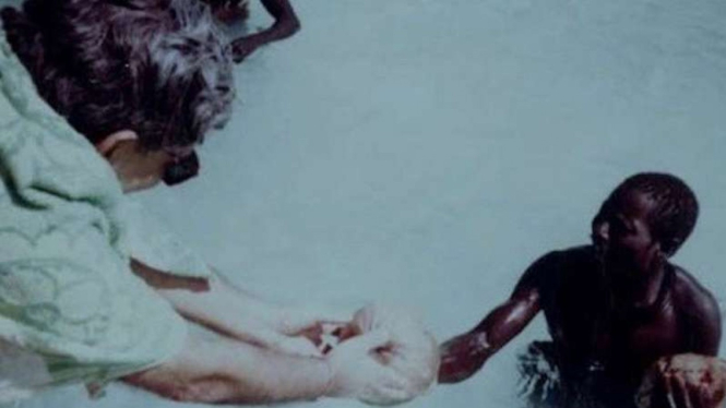 Sebuah foto yang memperlihatkan Pandit memberikan hadiah kelapa kepada salah-seorang anggota suku Sentinel pada 1991.