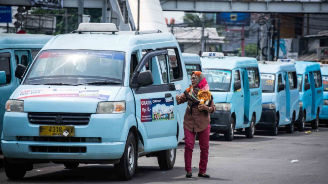 Penumpang turun dari angkutan umum Mikrolet, di Terminal Kampung Melayu, Jakarta