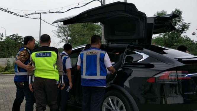 Mobil Tesla X dikerumuni petugas tol