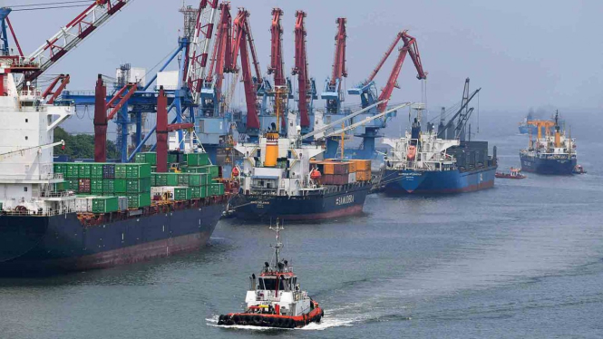Kapal tunda melintas di antara kapal yang melakukan bongkar muat peti kemas di Pelabuhan Tanjung Priok, Jakarta Utara