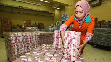 Petugas menata tumpukan uang kertas saat melakukan persiapan pengisian ATM di cash center PT Bank Negara Indonesia (Persero) Tbk (BNI), Jakarta