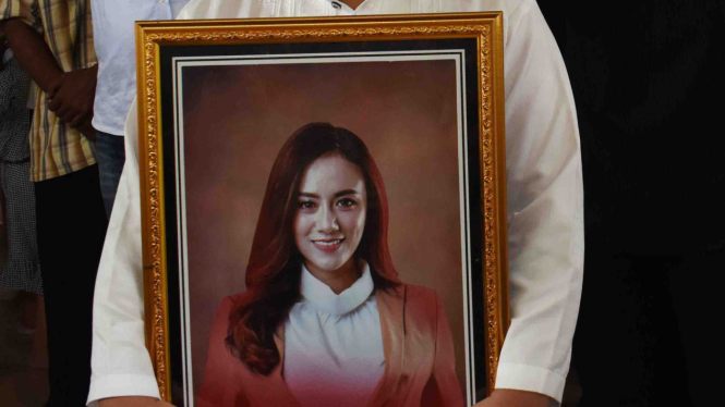 Seseorang membawa foto Dylan Sahara, istri vokalis band Seventeen, Riefian Fajarsyah alias Ifan di rumah duka Kelurahan Kepatihan, Ponorogo, Jawa Timur, Selasa, 25 Desember 2018.