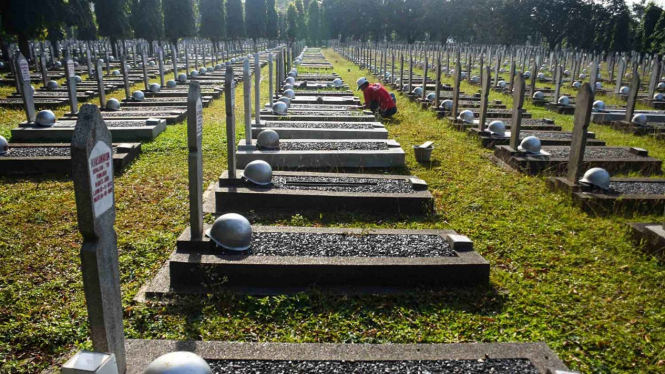 Pekerja memperbaiki makam yang rusak akibat tertimpa pohon di Taman Makam Pahlawan Kalibata, Jakarta. (Foto ilustrasi).